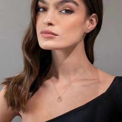 Woman wearing a 10K Gold Hanging Heart Pendant Necklace with Diamond around her neck 