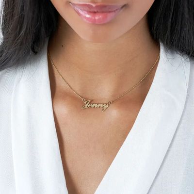 A gold name necklace that reads "Jenny" around a girl's neck
