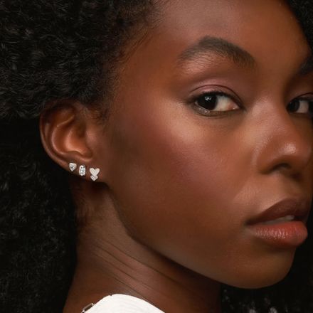 a close up of a person wearing a necklace and earrings