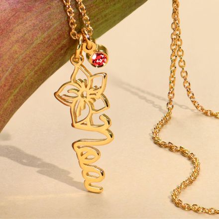 a close up of a gold ruby necklace on a table