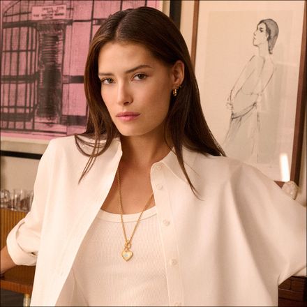 A woman wearing a gold heart locket