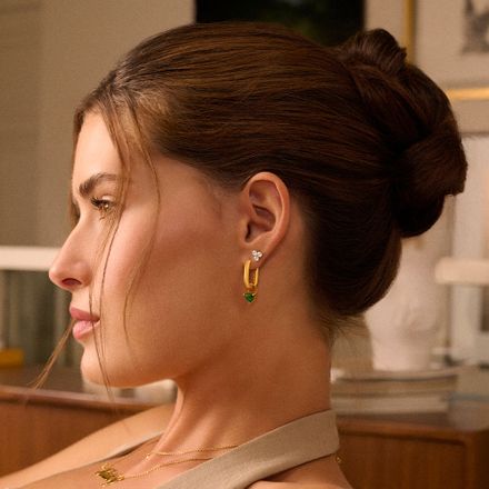 a woman wearing a necklace and a pair of earrings