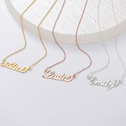 three personalized name necklaces on a white surface