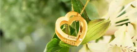 a gold necklace with a heart shaped pendant hanging from it