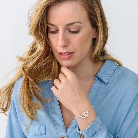 a sterling silver bracelet with an interlocking  heart shaped charms with engraving 