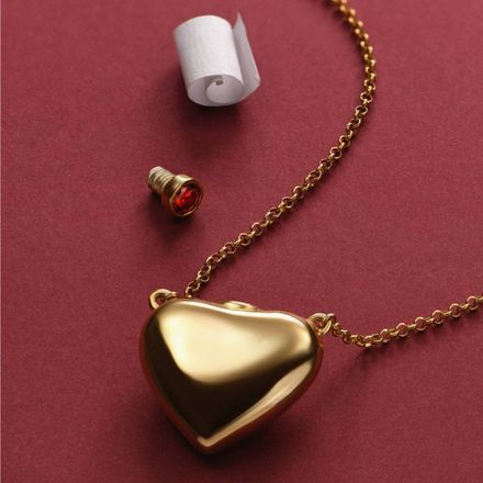 Love Note Puffy Heart Necklace in Gold a gold heart shaped pendant with a roll of toilet paper