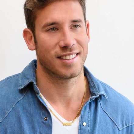 Man wearing a gold thick chain necklace with a name pendant that reads "Oscar"