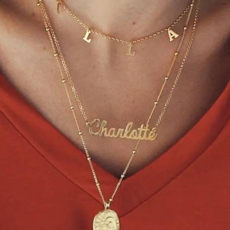 a close up of a person wearing a Charlotte Cursive Name Necklace