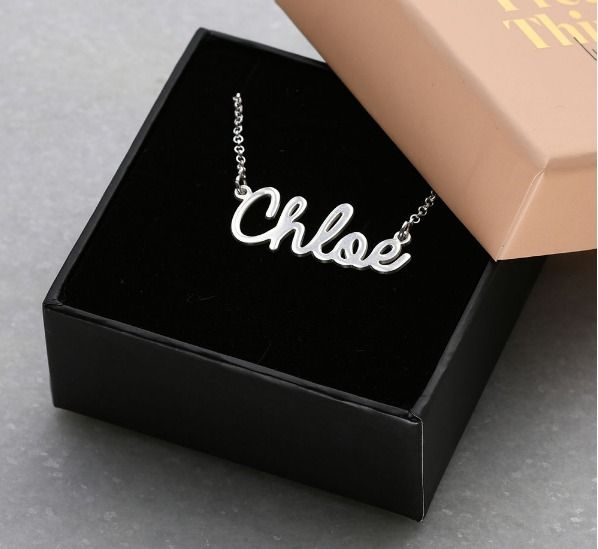 Silver name necklace by MYKA in an open square jewelry box
