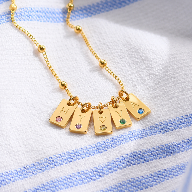 a close up of a five birthstone necklace on a towel