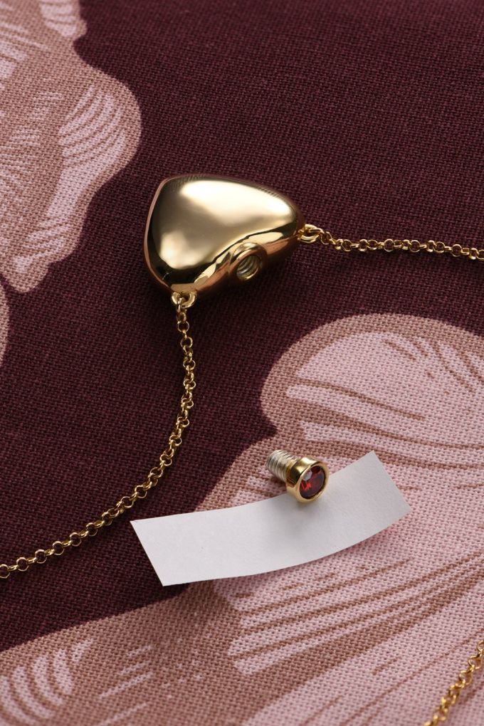 a gold necklace with a note attached to it