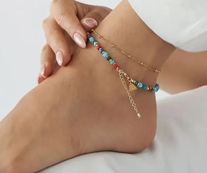 a woman's legs with a bracelet on it