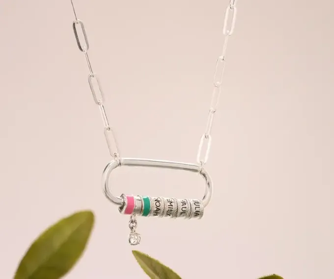a silver necklace with three engraved beads