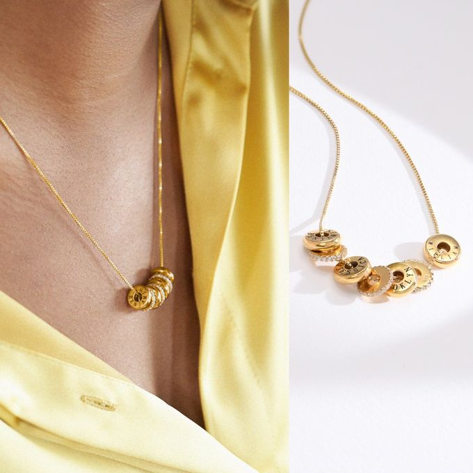 a woman wearing a yellow shirt and a gold necklace