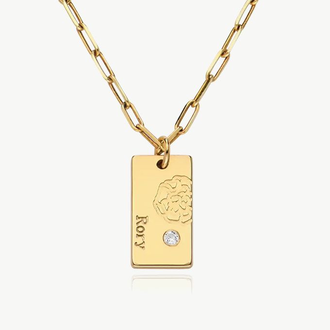 a gold necklace with a diamond on it