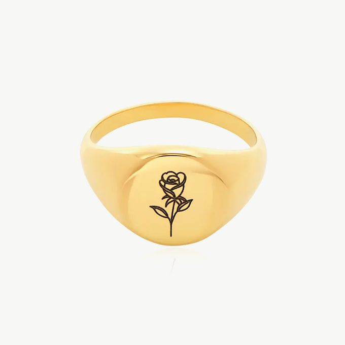 a gold signet ring with a rose on it