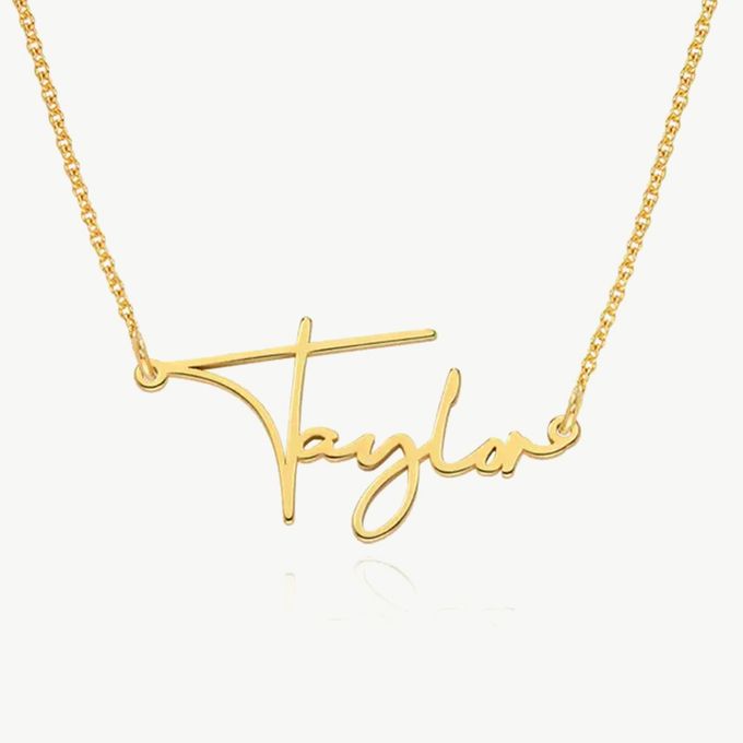 a gold necklace with the word taylor on it