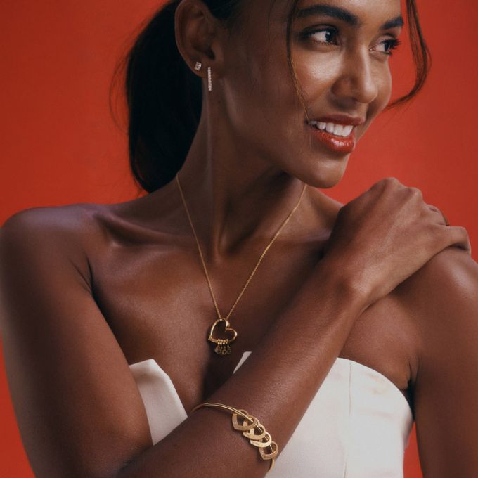 a woman in a white dress wearing a gold necklace