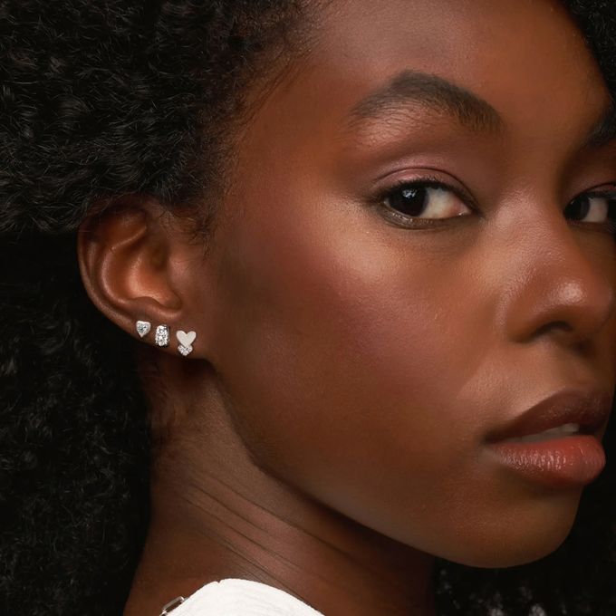a close up of a person wearing a necklace and earrings