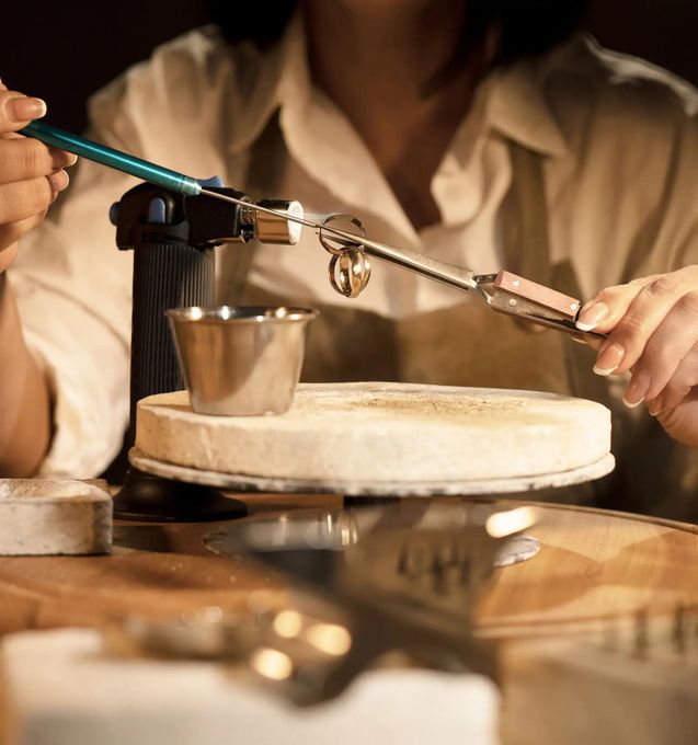 a woman using tools in order to create jewelry in-house