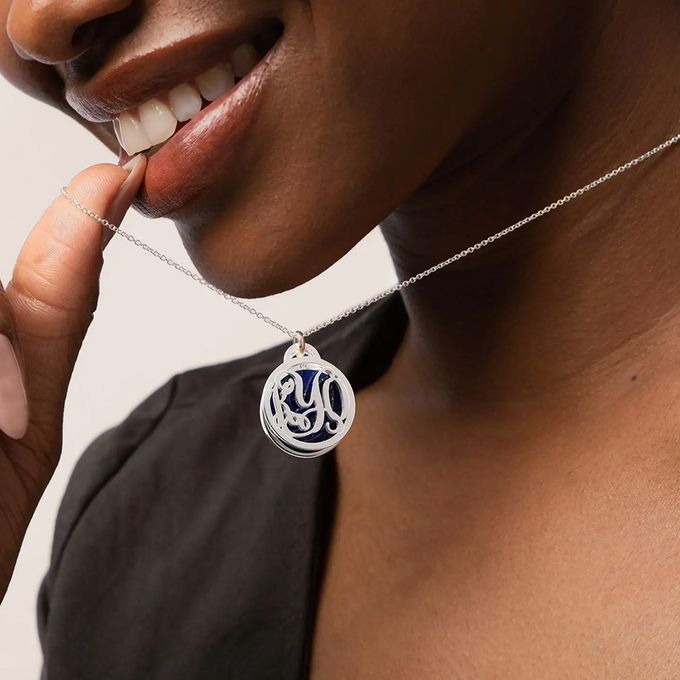 a woman wearing a necklace with the letter s on it
