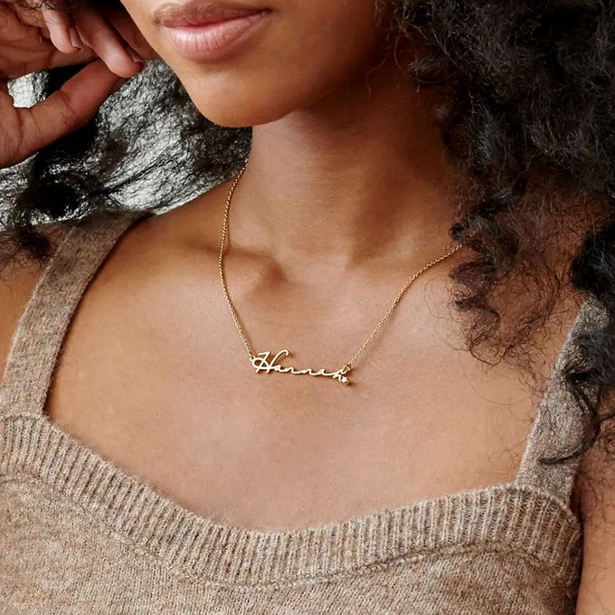 a woman wearing a gold necklace with the name hannah on it