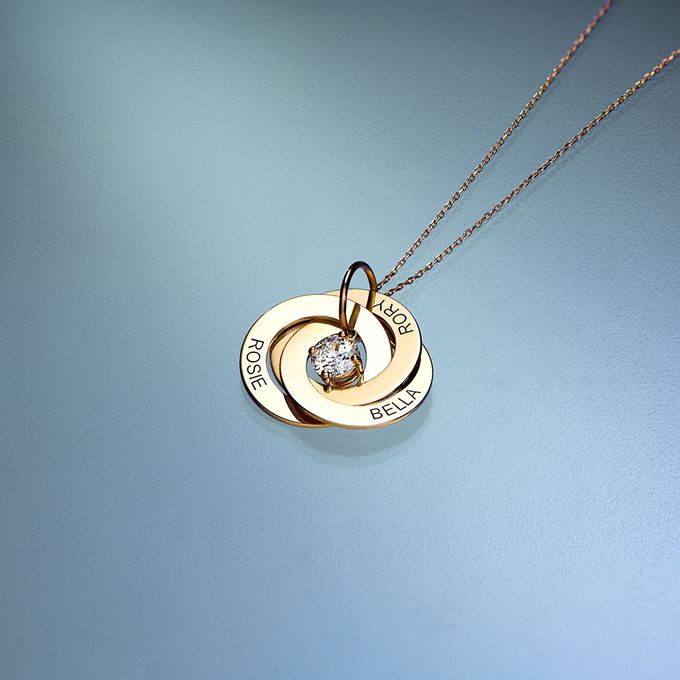  gold necklace with a diamond on a blue backgroun