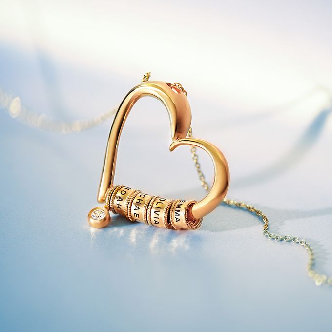 a gold necklace with a heart shaped pendant
