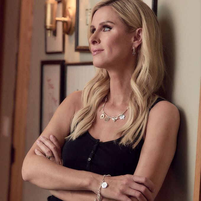 a woman wearing a silver matching charm necklace and bracelet