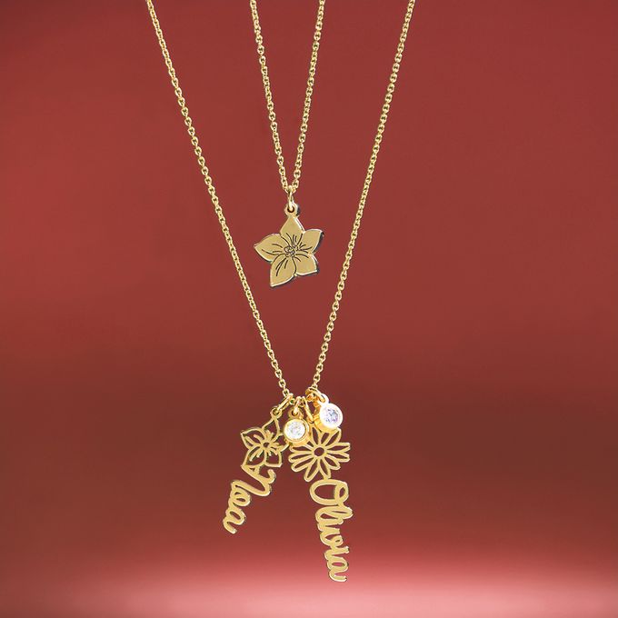 a gold necklace with a birth flower and stone and a name on it