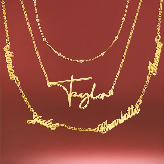 Three gold necklaces with names on on a red background