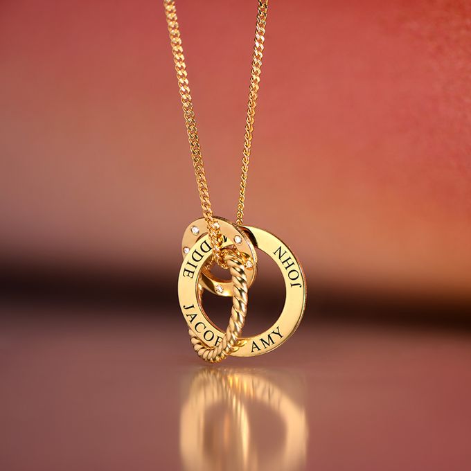 a gold necklace with three intertwined circles with name engraving