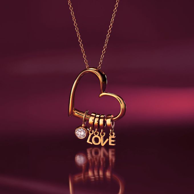 a gold necklace with a heart and the word love on it