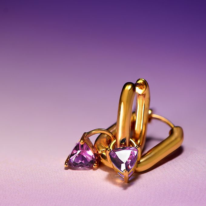 a pair of gold rings with amethyst stones