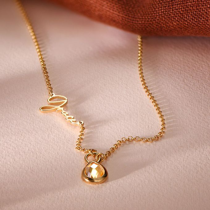 a gold necklace with a heart on it