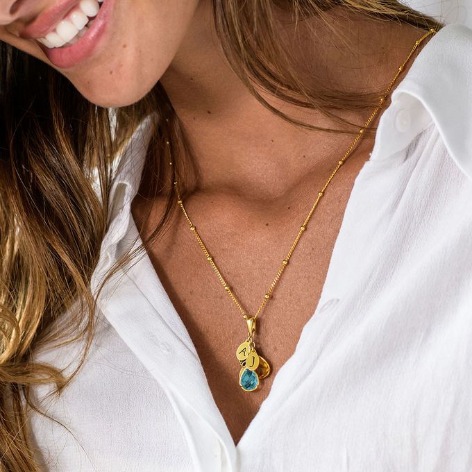 a woman wearing a white shirt and a gold necklace