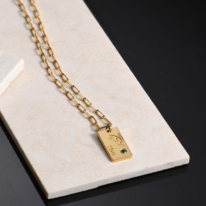 a gold necklace with a name, flower and birthstone