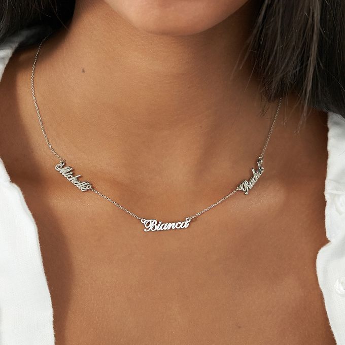 a close up of a woman wearing a name necklace