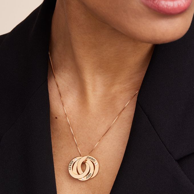 a close up of a person wearing a rose gold necklace