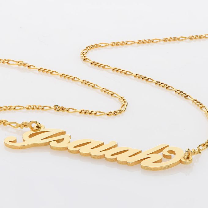 a gold name necklace with a chain on a white background