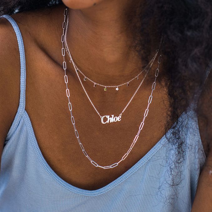 a close up of a person wearing layered necklaces