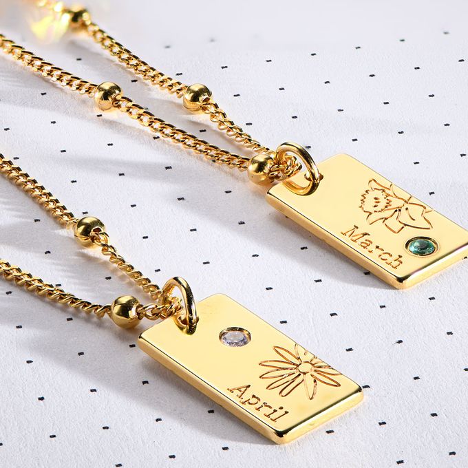 a couple of gold necklaces sitting on top of a table