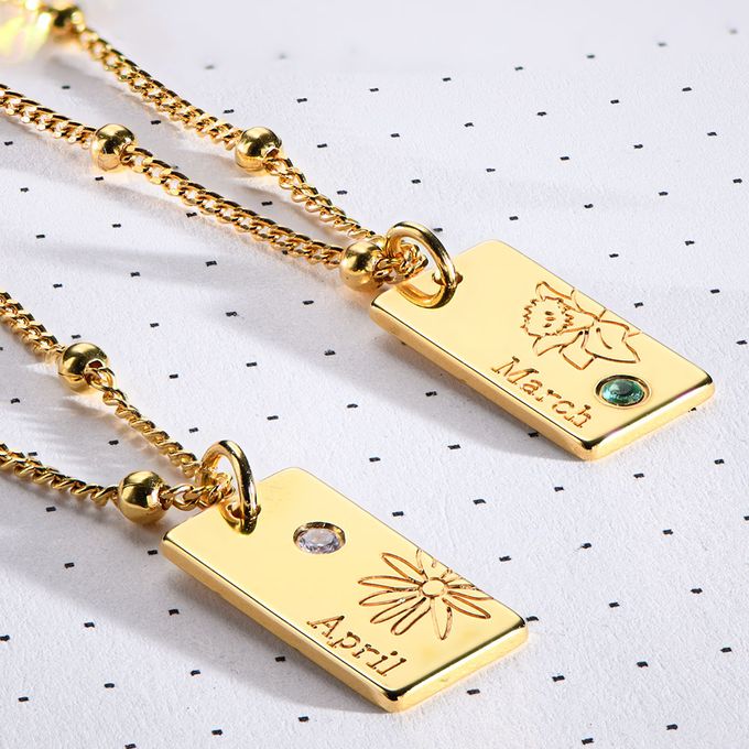 a couple of necklace tags that are sitting on a table