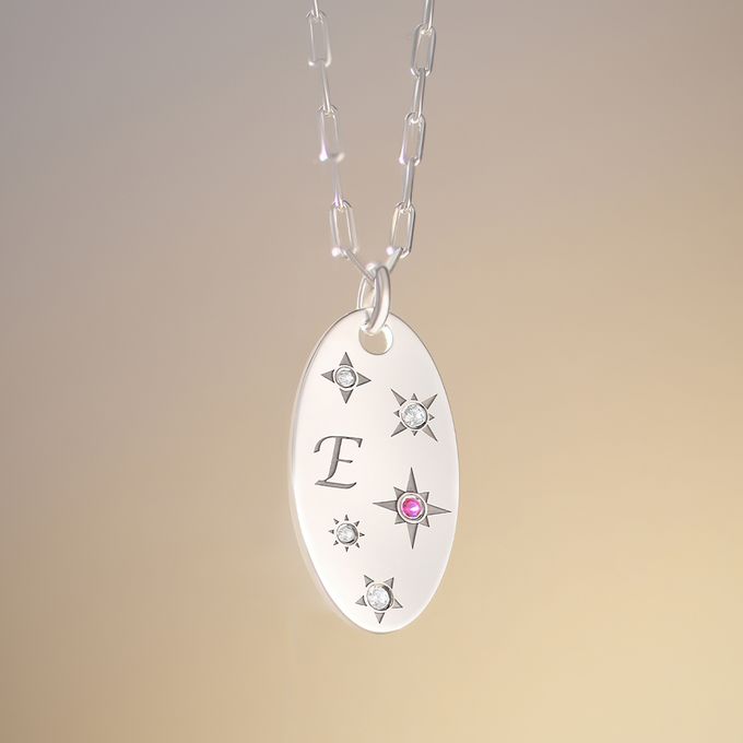 a silver necklace with a pink stone on it