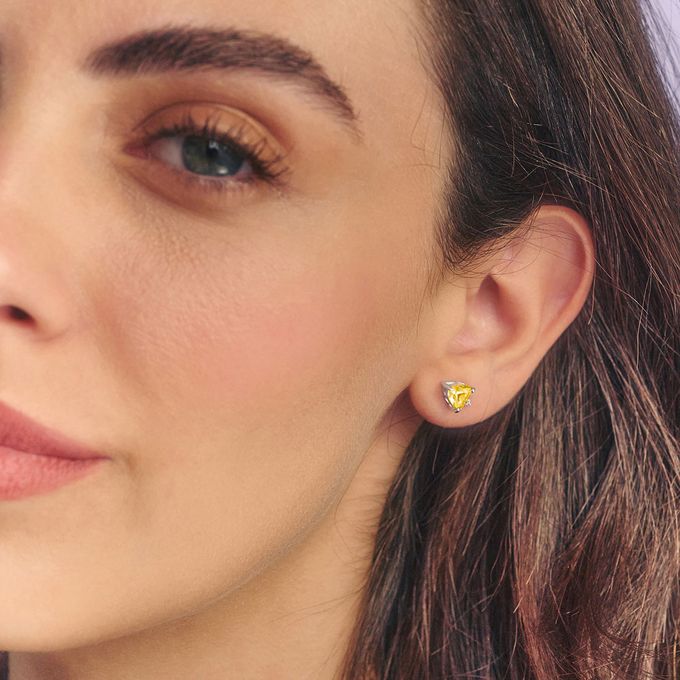 a close up of a person wearing a pair of earrings