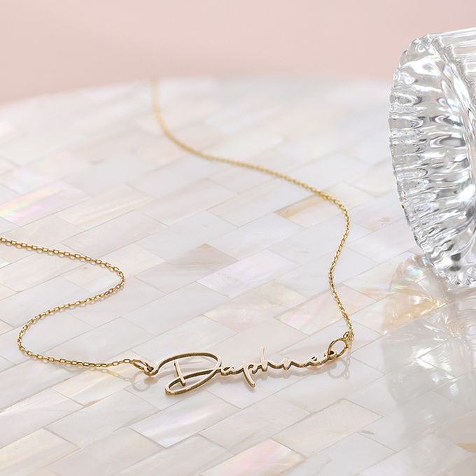 a gold plated necklace with a name on it
