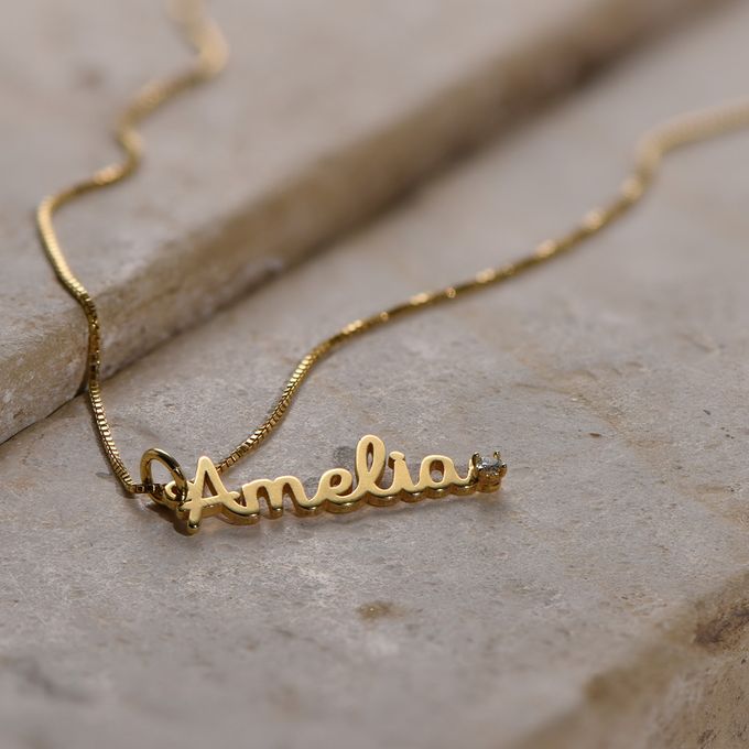 a personalized name necklace on a rock