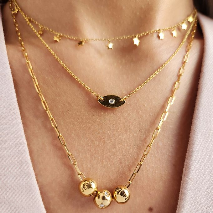 a close up of a person wearing layered necklaces