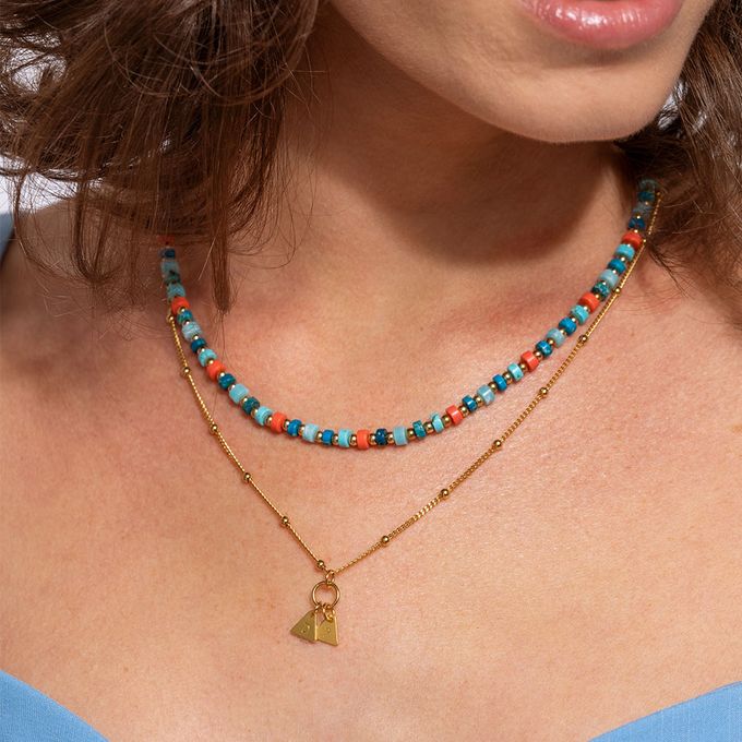 a close up of a woman wearing a colorful beaded necklace