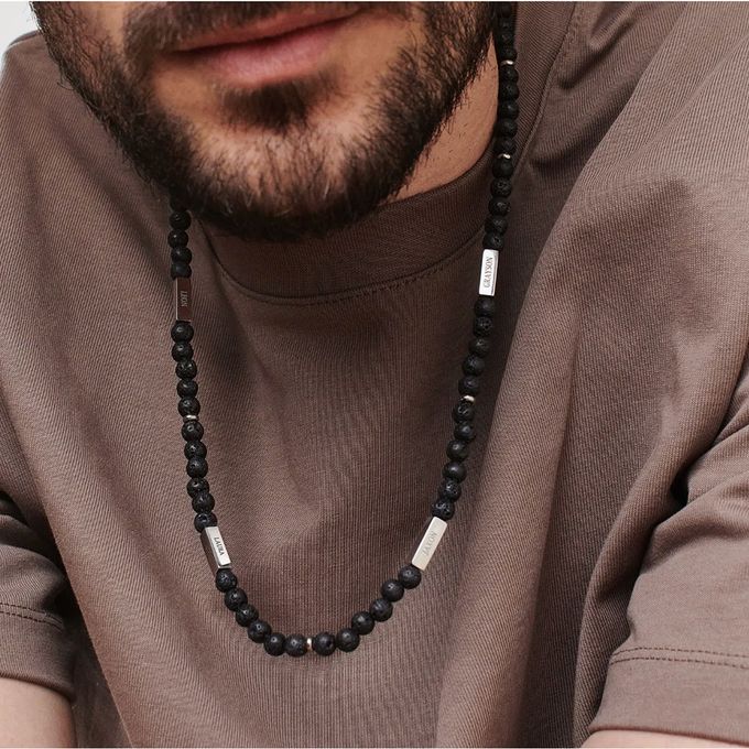 a close up of a man wearing a beaded necklace